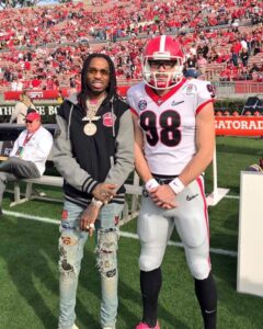 Man and football player on field